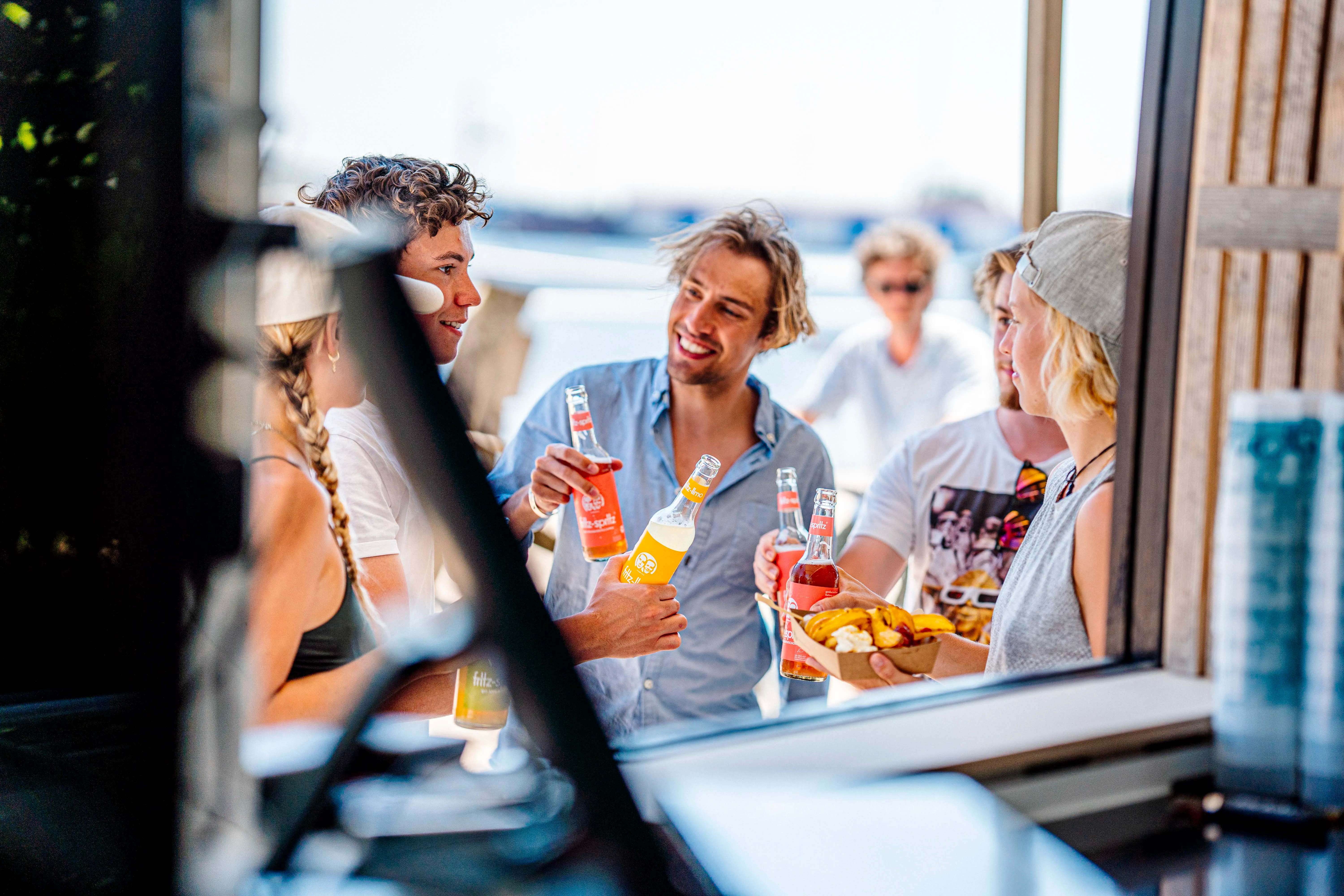 Freunde mit Drinks am Wasser bei Supieria