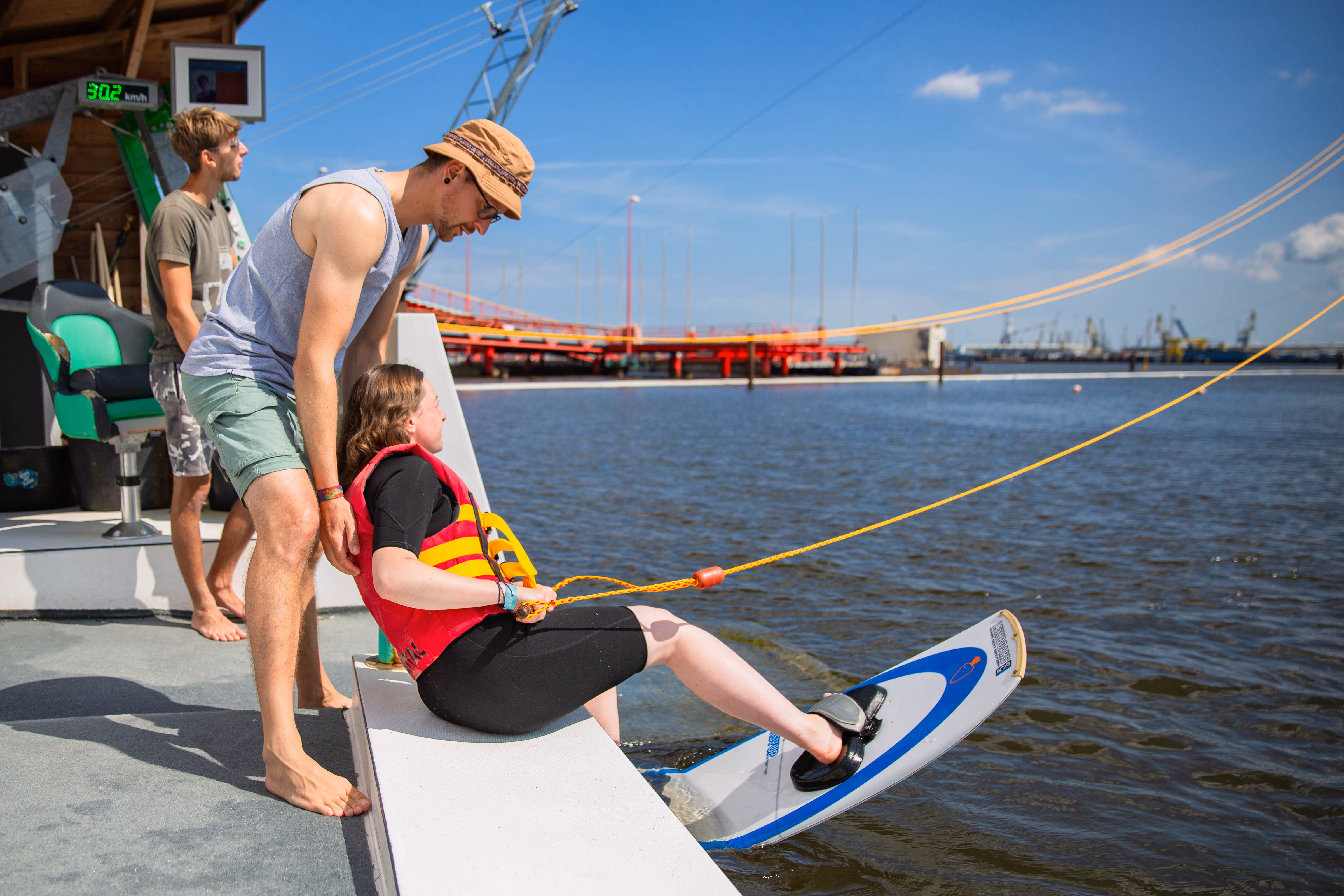 Supieria Crew unterstützt einen jungen Gast beim Start mit dem Wakeboard